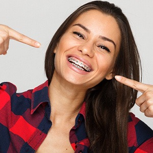Woman in red and black plaid shirt smiling with braces