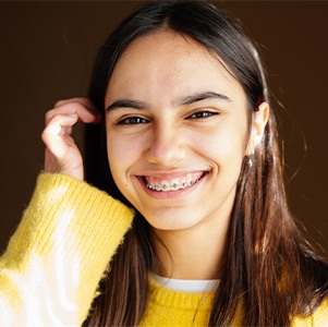 a woman wearing clear braces from her orthodontist in Enfield
