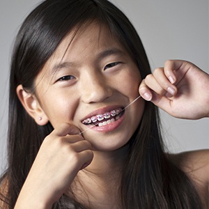 Teen flossing to avoid orthodontic emergencies
