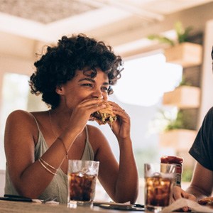 Group of friends smiling while eating at restaurant