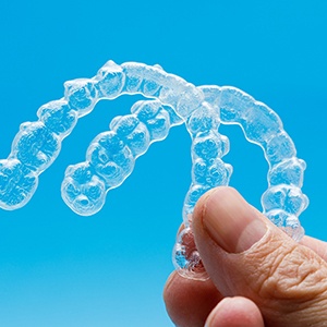 person holding two clear aligners