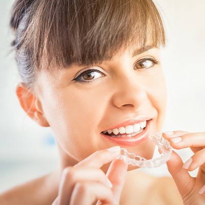 Woman placing an Invisalign tray