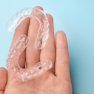 Person holding two Spark clear aligners in their hand