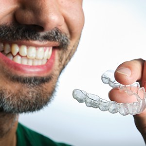 Man preparing to place clear aligner on his teeth