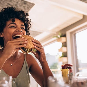 Smiling woman preparing to eat a burger