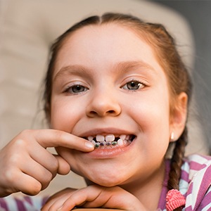 Child pointing to phase one pediatric orthodontic appliance