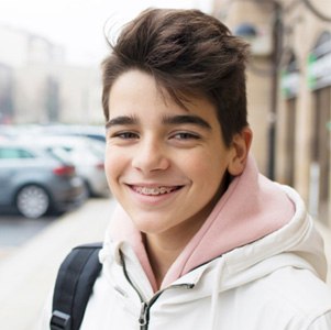 Smiling boy wearing teen orthodontics in Enfield