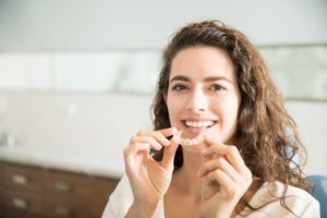 Woman inserting upper Invisalign aligner