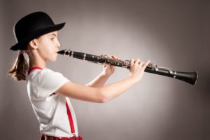Girl in black hat playing clarinet