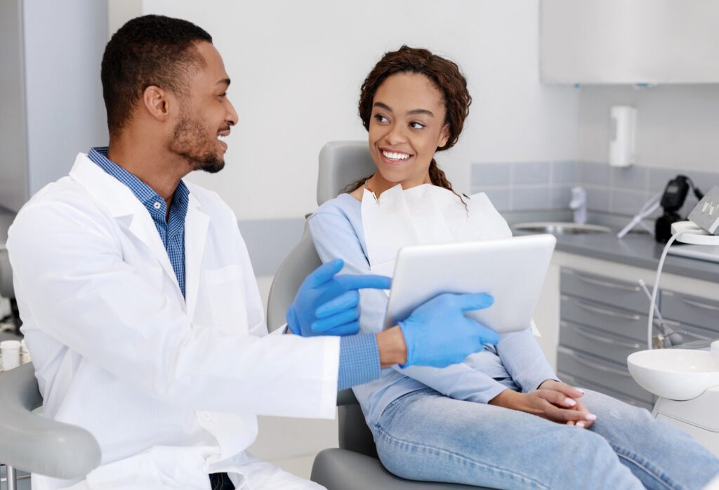 Orthodontist showing smiling patient image on tablet